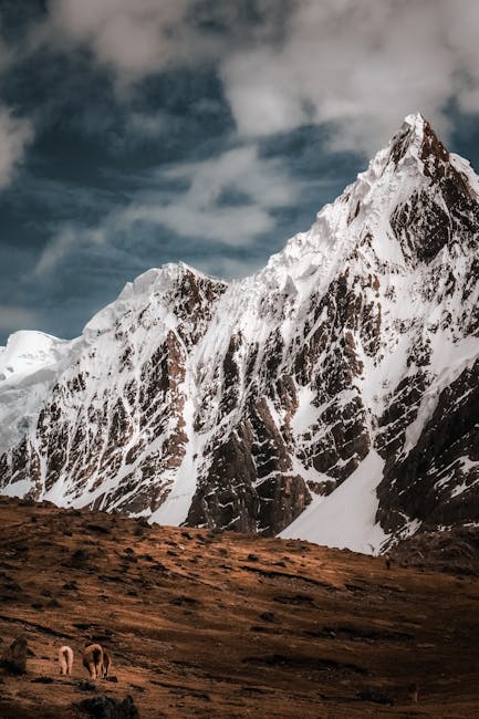 Stunning snowcapped Andes Mountains with a dramatic sky in Peru's scenic Cusco region.