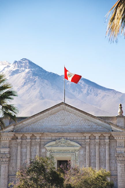 Colonial architecture in Arequipa, Peru, with Peruvian flag and Andes background.