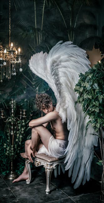 Artistic photo of a winged angel seated in an opulent, indoor setting, evoking fantasy and mythology.