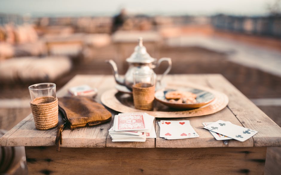 A warm scene of Moroccan tea and cards on a rooftop wooden table in Marrakesh.