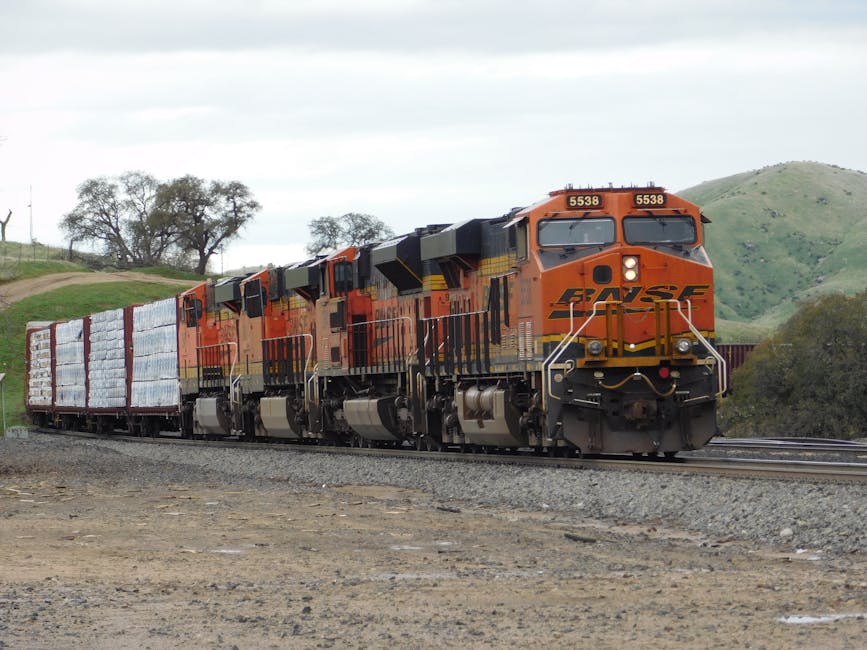 BNSF freight train transporting goods through a rural landscape on a clear day.