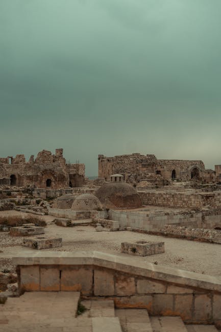 Explore the ancient historical ruins of Aleppo, Syria captured under a dramatic cloudy sky.