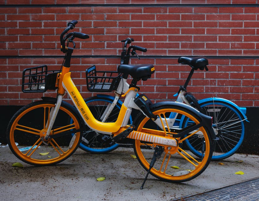 Urban scene of vibrant bicycles parked against a red brick wall in Shanghai, China.