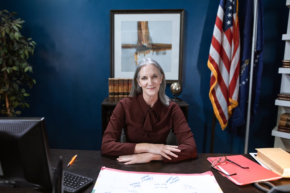 Professional woman in office with flags, showcasing leadership and confidence.