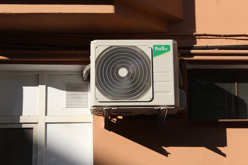 A Ballu air conditioner condenser unit mounted on a building exterior, showcasing modern HVAC technology.