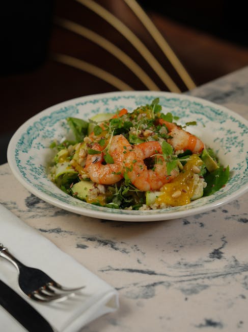 Delicious shrimp salad with fresh avocado and greens in a decorative bowl.