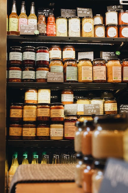 Assorted jars and bottles neatly arranged on market shelves in a Polish store.
