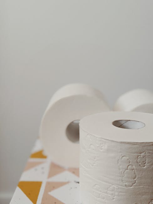 Stylish toilet paper rolls on a patterned table indoors.