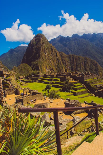 Breathtaking view of Machu Picchu with lush green terraces under a clear blue sky in Cuzco, Peru.