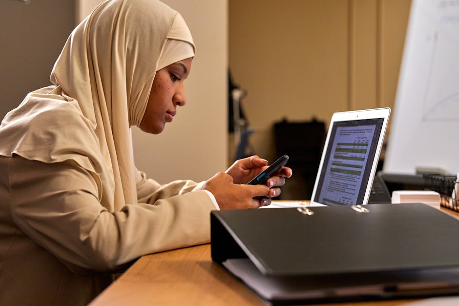 professional Arab young woman updating LinkedIn profile laptop office