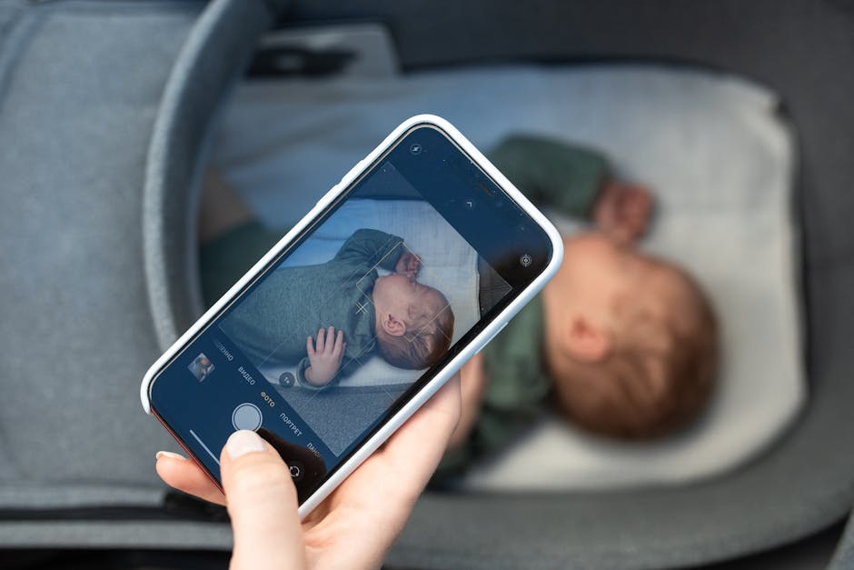 A smartphone capturing a peaceful newborn baby sleeping in a crib, highlighting modern parenthood.