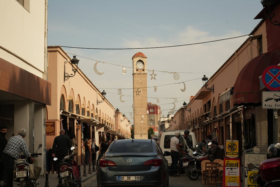 Vibrant marketplace street scene featuring a prominent clock tower and bustling activity.