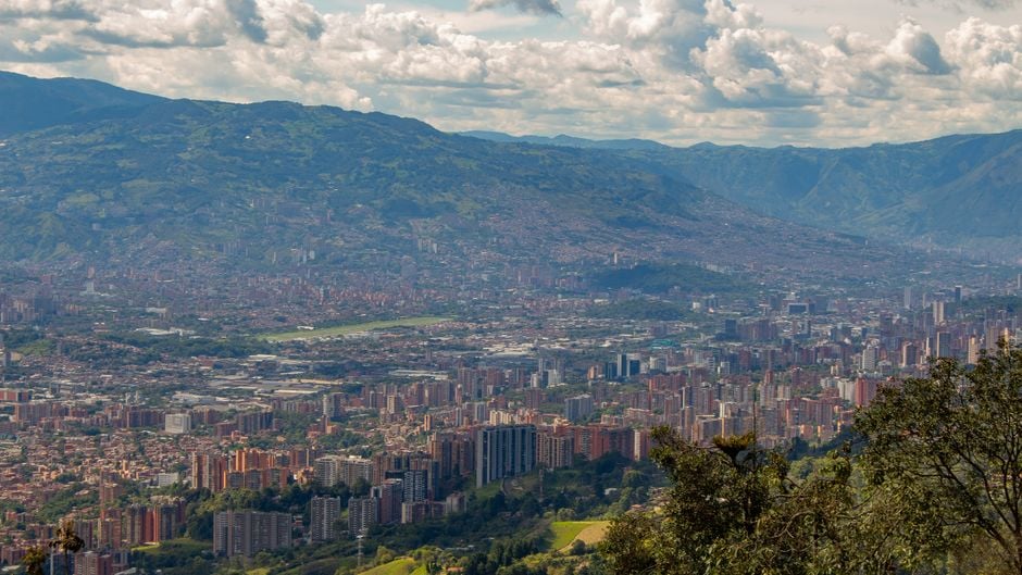 Colombian cafe remote worker laptop Medellin skyline pexels