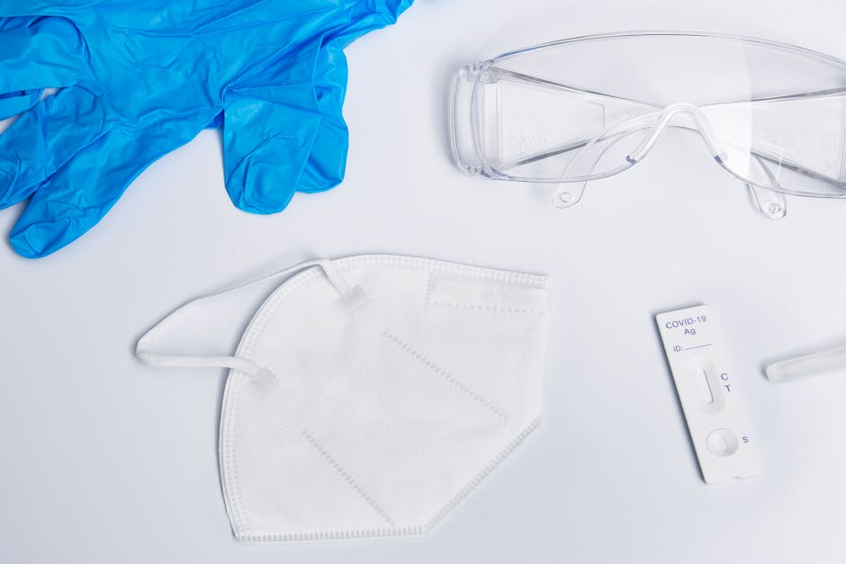 Flat lay of protective gear and a COVID-19 test kit, indoors.