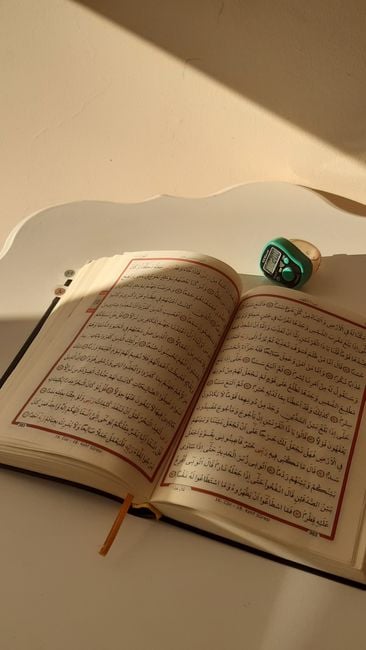 smartphone prayer app tasbih digital counter beside Quran wooden table