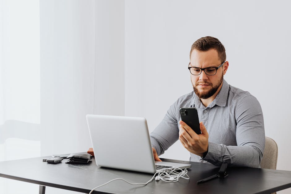 Arabic professional checking job alerts on smartphone laptop government jobs