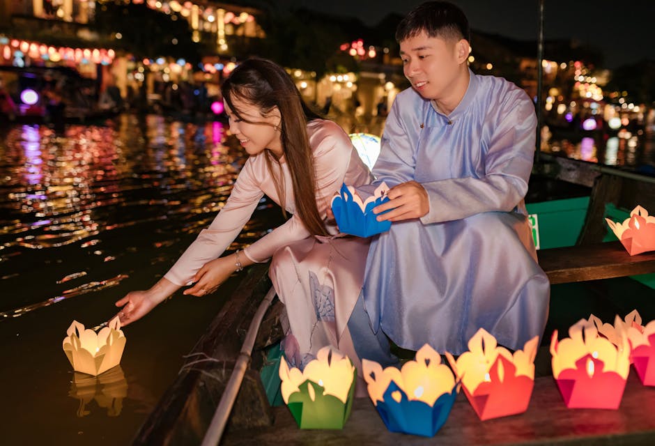 Couple enjoying lantern festival on Hoi An river at night.
