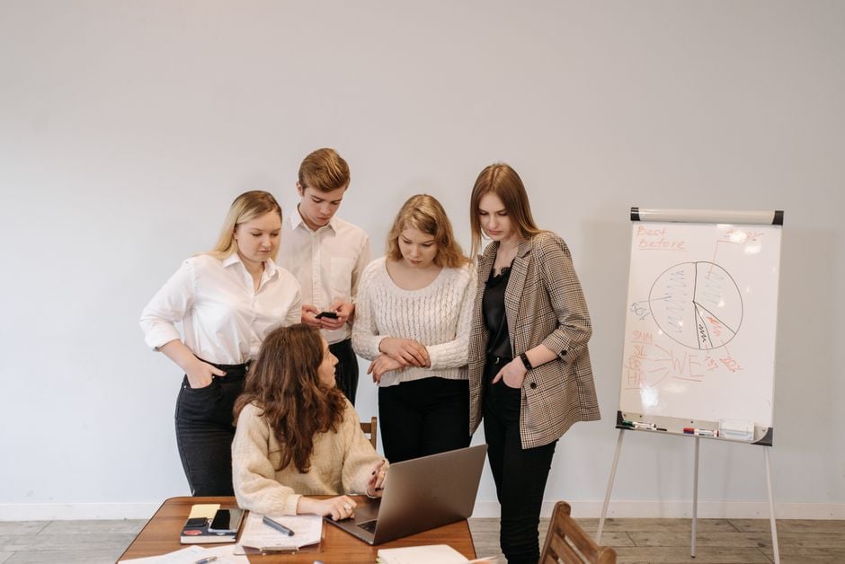 female startup founders discussing tokens laptop whiteboard crypto community