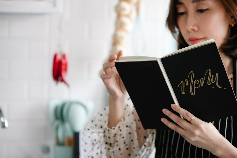 Close-up of a woman reading a menu indoors with a blurred cozy kitchen background.