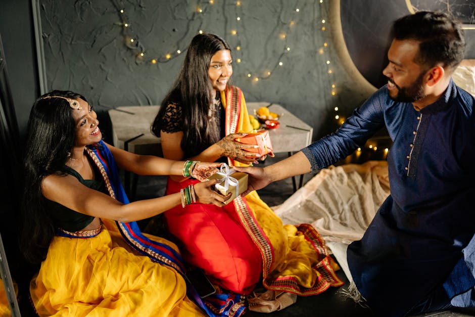 Three adults joyfully exchange gifts during a Diwali celebration indoors, wearing traditional Indian attire.