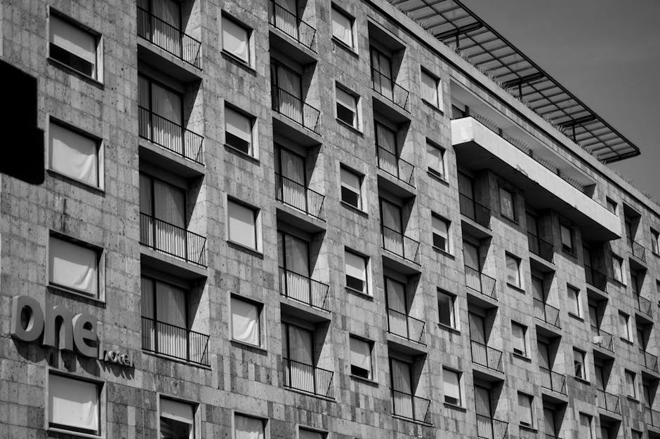 Monochrome view of a modern hotel building with geometric window designs and balconies.