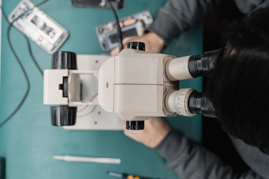 phone repair shop technician hands replacing smartphone screen spare parts