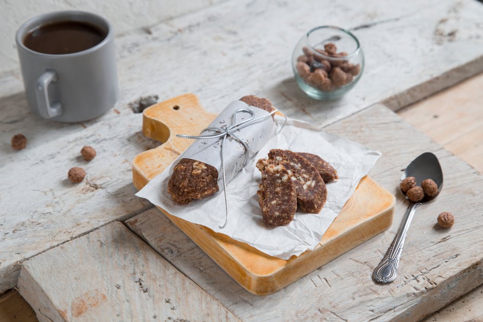 Delicious nutty chocolate salami presentation with coffee on a rustic wooden board. Ideal for food photography.