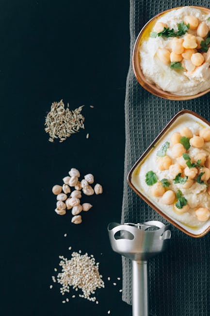 Flat lay of creamy hummus with chickpeas and herbs, perfect for Mediterranean cuisine enthusiasts.