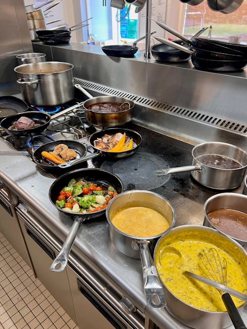 A variety of dishes in pots and pans cooking on a professional kitchen stovetop.