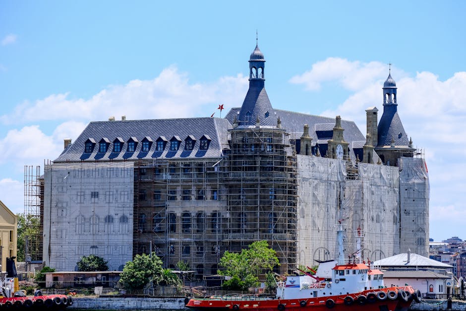 Historic Haydarpaşa Station under restoration with docked boat in Istanbul, Turkey.