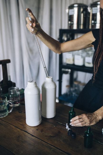 zero waste cosmetics refill station woman filling bottle