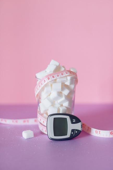 Glucometer and sugar cubes highlight diabetes awareness on a pink background.