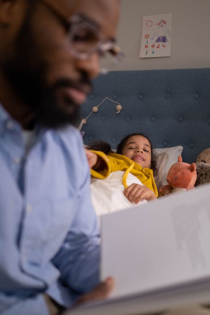 A father reads a bedtime story to his daughter, creating a warm and loving atmosphere.