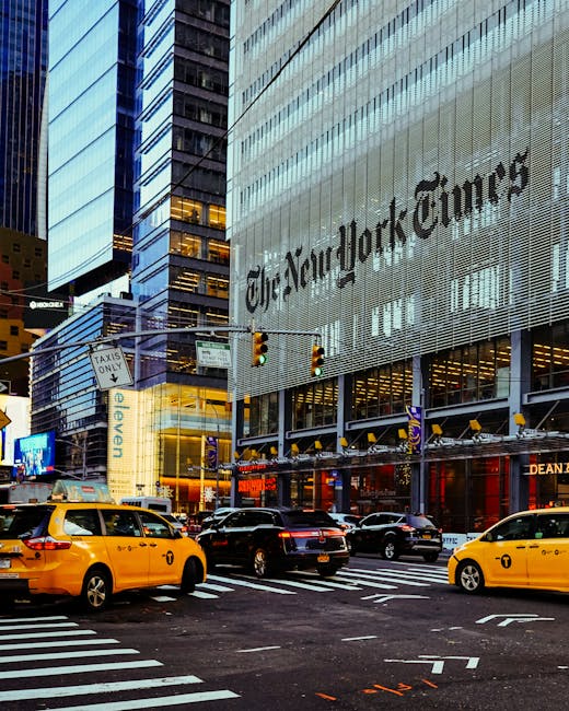 Street view of the New York Times Building surrounded by taxis in bustling New York City.