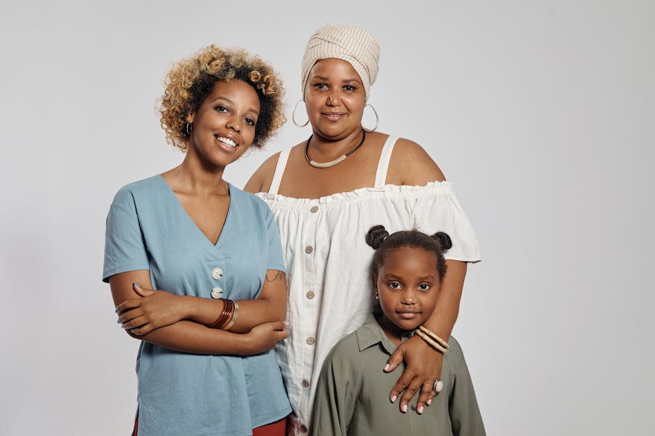 Portrait of a diverse family featuring a mother with her daughters, posing confidently in a studio setting.