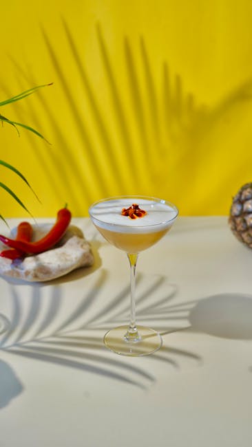 Stylish cocktail garnished with chili on a tropical theme table.