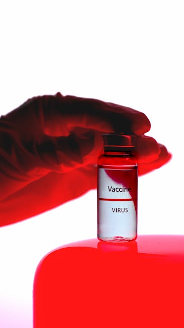 A close-up of a vaccine vial held by a gloved hand under red lighting, conveying medical research.