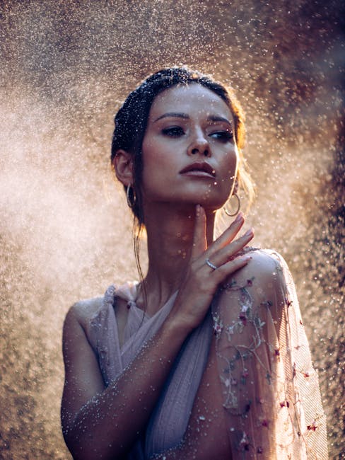 A captivating portrait of a woman enveloped in a mystical water spray with dramatic lighting.
