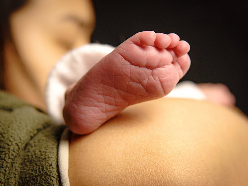 Tender moment with baby's foot resting on a parent's chest, capturing love and warmth.
