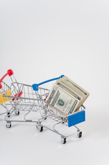 A close-up of miniature shopping carts filled with dollar bills, symbolizing finance and shopping.