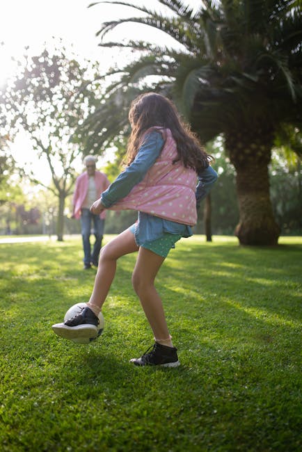 Grandfather and grandchild enjoying a fun soccer game on a sunny day in a picturesque park.