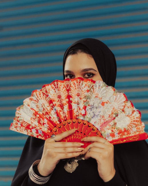 middle aged arab woman holding fan during hot flush perimenopause Pexels