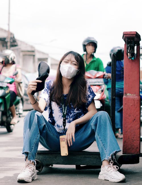 Casual scene of a young woman smiling while sitting on a street cart, amidst city hustle.