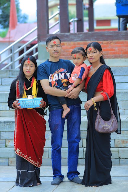 A family in traditional attire poses at a Nepalese temple, showcasing cultural heritage.