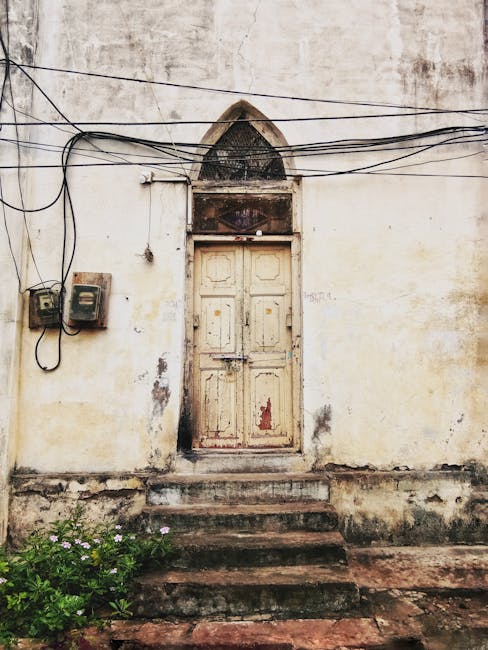 Aged building facade with a rustic wooden door in India, showcasing historical charm.