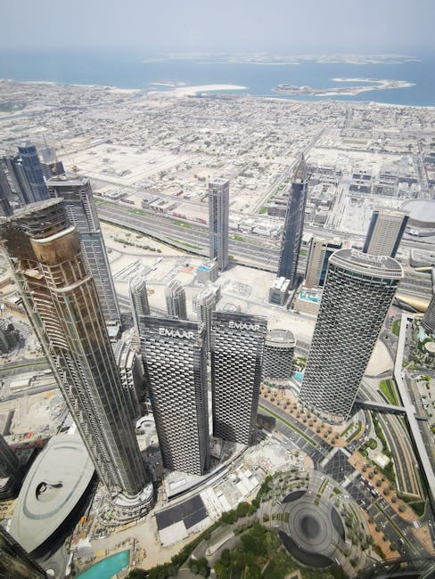 Stunning aerial view of high-rise buildings in Dubai, with coastal scenery in the background.