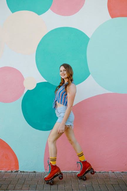 Young woman in retro roller skates posing against a vibrant mural.
