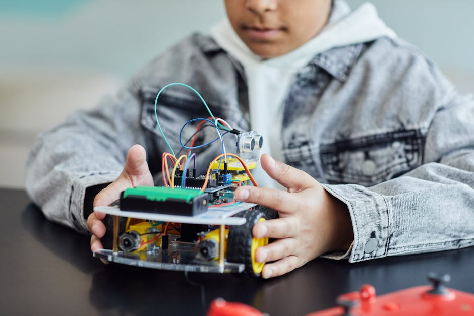 A child working on a DIY robotics project with wires and wheels, showcasing innovation and creativity.