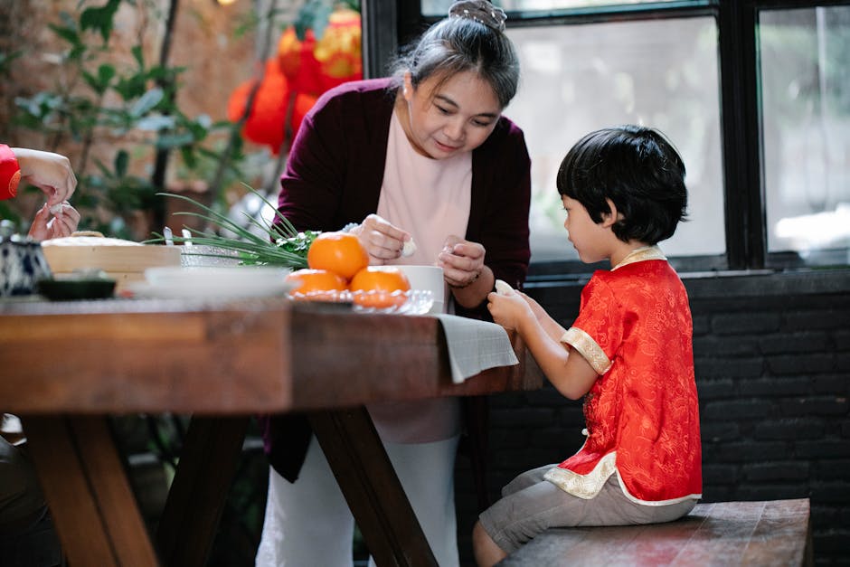 A grandmother guides her grandson in making traditional dumplings at home, celebrating culture and family.