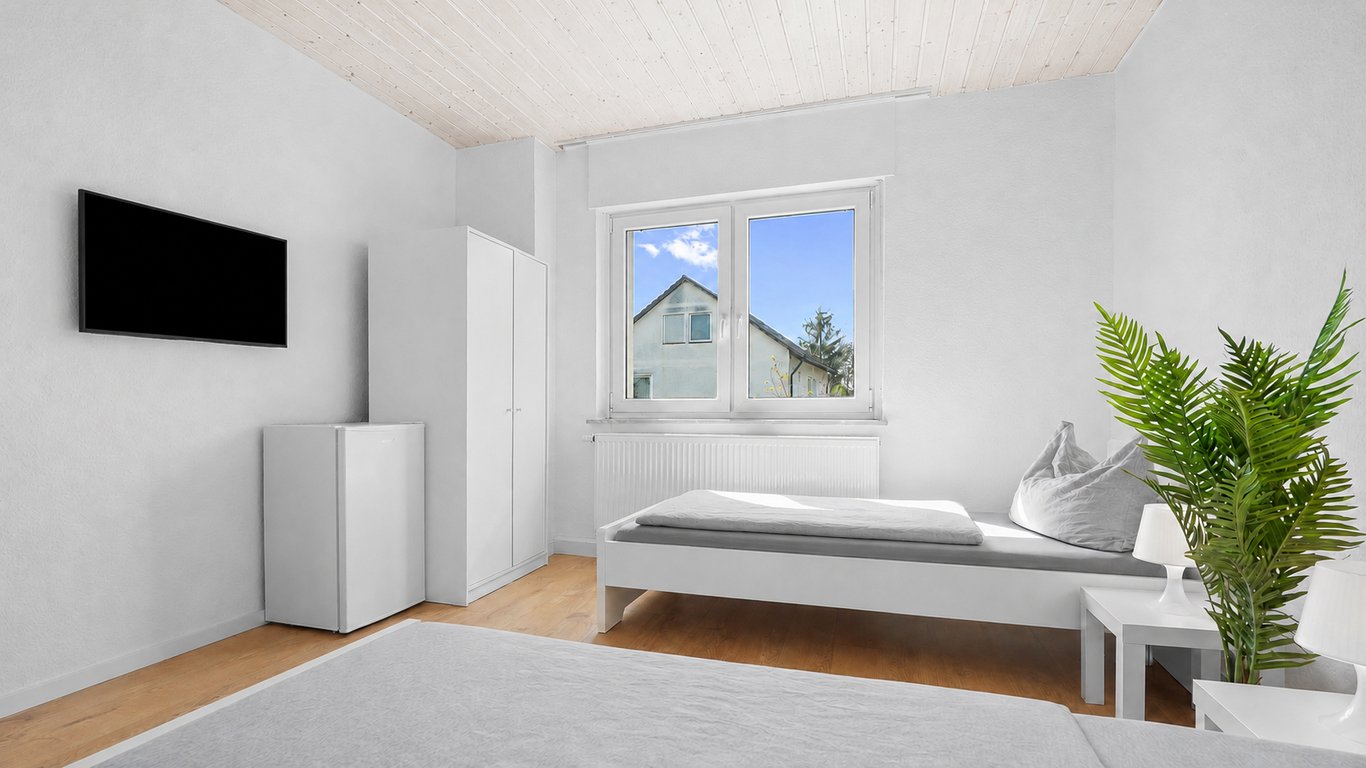 bedroom with white single bed wall-mounted TV and wood plank ceiling